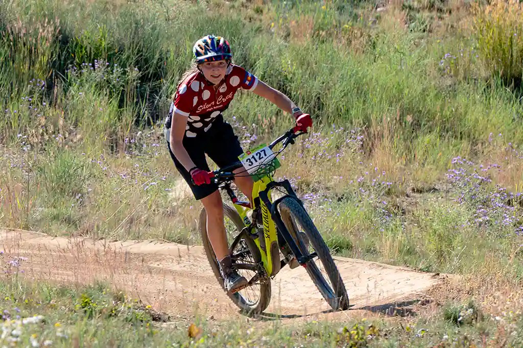 A Silver Creek female student high school mountain bike team member rails one of the final corners at Frisco