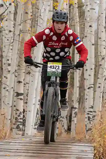 Silver Creek high school mountain biker in front of fall colors
 